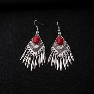 Detail of bohemian retro earrings with red turquoise stones and metal leaf tassels