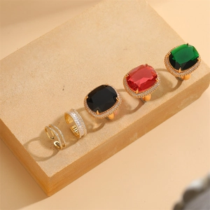 Adjustable geometric zircon rings with red green black gemstones on beige stone