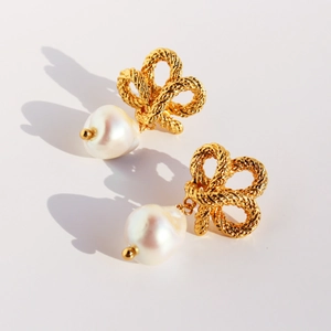 Vintage twisted gold knot earrings with baroque pearl drops on a clean white background