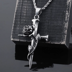 Detail of vintage silver cross pendant with rose vine on a twisted rope chain necklace