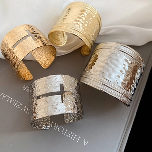 Détail de joncs croisés évidés à texture martelée en finitions dorée et argentée