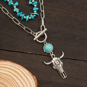 Detail of vintage bohemian layered necklace featuring turquoise beads and bull skull pendant