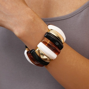 Detail of wide resin stretch bracelet with white, black, amber, and gold metal modules