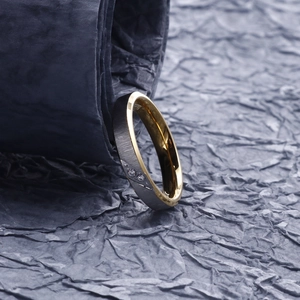 Macro shot of two-tone stainless steel ring with brushed finish and zircon inlay