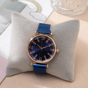 Detail of rose gold quartz watch featuring a sunray blue dial and magnetic mesh strap