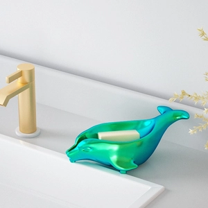 Blauw-groene dolfijn zeepschaal op wastafel met een geel stukje handzeep