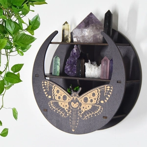 Detail of round wooden moon shelf with moth carving and mystical boho aesthetic