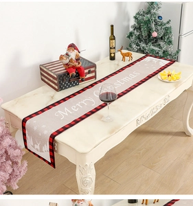 Détail d'un chemin de table de Noël avec bordures à carreaux rouges et motifs de cerf