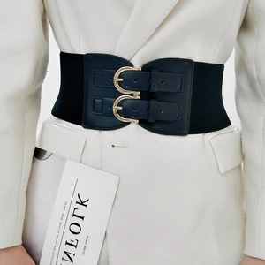 Close-up of a wide elastic navy belt with double golden buckles on a white suit