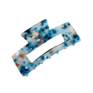 Square acrylic hair claw clip with blue and beige terrazzo pattern on white background