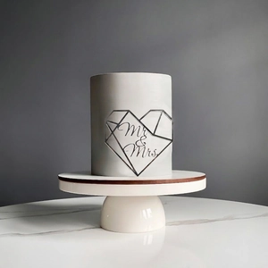 Close-up of geometric heart-shaped silver mirror cake topper featuring Mr & Mrs lettering