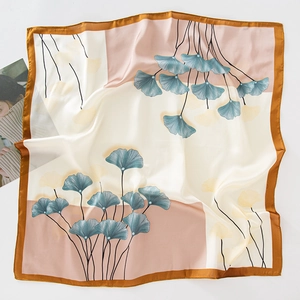Detail of square silk scarf with ginkgo leaf print in beige and pink tones