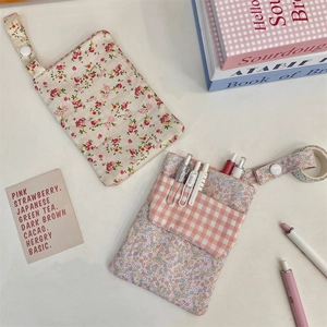 Floral fabric pocket organizer for nursing pens featuring a snap button and lanyard