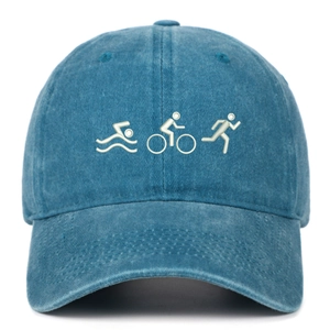 Detail of embroidered triathlon icons on vintage washed blue cotton baseball cap