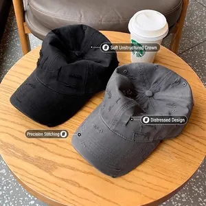 Vintage distressed baseball caps in black and grey with precision stitching on a table