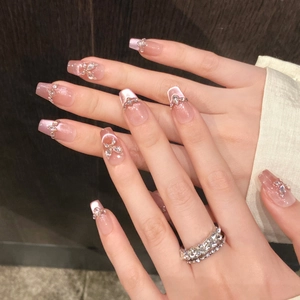 Detail of pink cat eye nails with shimmering crystal butterfly and long coffin shape
