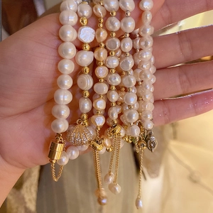 Elegant gold-plated freshwater pearl bracelets featuring shell pendants and adjustable chains