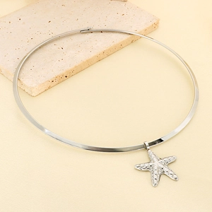 Detail of silver textured starfish pendant on a minimalist stainless steel choker necklace
