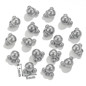 Close-up of small stainless steel three-ball charms with precise 8.5mm size markings