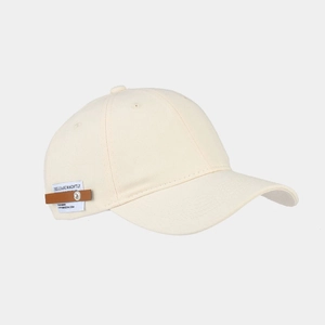 Close-up of beige baseball cap featuring leather patch and metal rivet detail