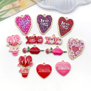 Détail de breloques en émail rose et rouge pour bijoux avec motifs cœurs et mots XOXO