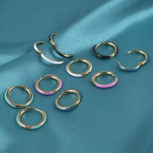 Colorful enamel and gold plated stainless steel small hoop earrings on silk background
