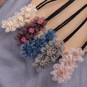 Detailed close-up view of various color chiffon flower bun hair makers styling tools
