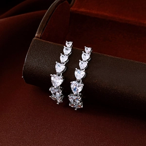 Macro shot of silver-plated heart-shaped drop earrings with clear zircon stones