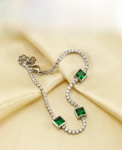 Detail of titanium steel tennis bracelet with square green zircon stones on silk