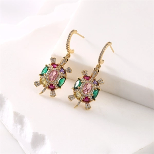 Detailed macro view of turtle earring featuring colorful zircons and golden metal finish