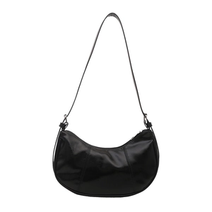 Minimalist black crescent hobo bag in glossy faux leather with silver hardware accents