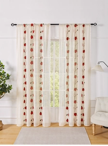 Lace curtain detail showing red floral embroidery and delicate scalloped lace edges