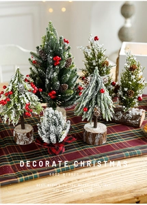 Miniature snowy Christmas tree with red berries on rustic wooden base for table decor