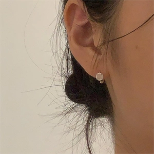 Minimalist round cubic zirconia stud earrings with classic prong setting on model ear