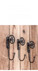 Gros plan de trois crochets muraux vintage en fonte style industriel sur fond en bois