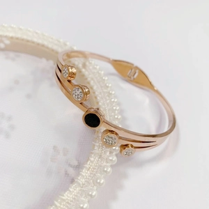 Rose gold titanium steel watch-style bangle with black circle and zircon accents
