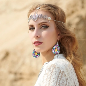 Detail of bohemian silver hollow flower forehead chain and colorful rhinestone drop earrings