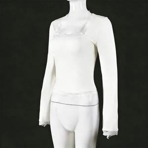 Detail of delicate lace trim on white long sleeve top showing fabric texture and hem