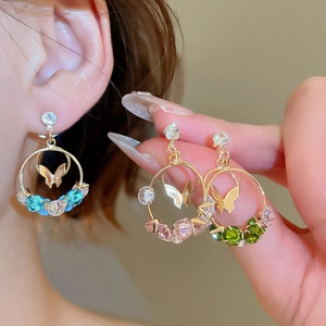 Close-up of golden butterfly earrings featuring vibrant zircon crystals in multiple colors