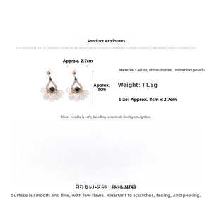 Detail of water drop pearl earrings with shell tassel and crystal leaf design