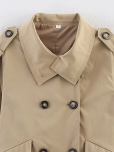 Close-up of khaki double-breasted trench coat showing lapel, shoulder tabs and buttons