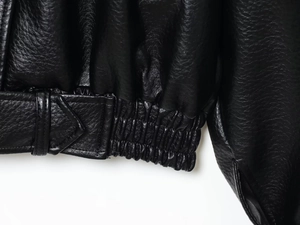 Detail of the high-quality black leather jacket hem with elastic waist and adjustable straps