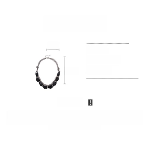 Détail d'un collier multicouche en acrylique avec breloques géométriques noires