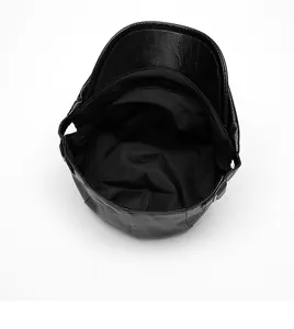 Detail view of leather newsboy hat interior with fabric lining and metal adjustment buckle