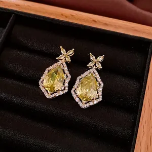 Boucles d'oreilles pendantes dorées avec pierres jaunes poire et accents de zircon blanc