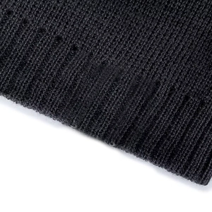 Detail of black ribbed knit beanie featuring distressed hollow-out design and thick texture