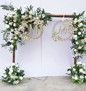 Close-up of wooden Mr and Mrs wedding chair signs featuring floral wreath laser-cut design