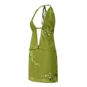 Detail of sequin floral embroidery on a green backless halter neck dress with beads