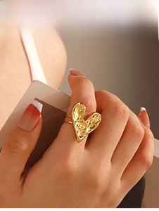 Detailed view of gold heart ring with irregular hammered texture on double band