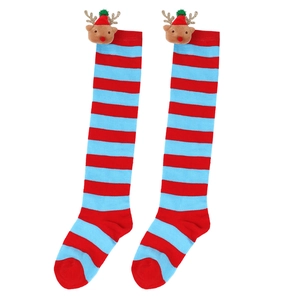 Close-up of red and blue striped Christmas stockings with cute reindeer doll decoration